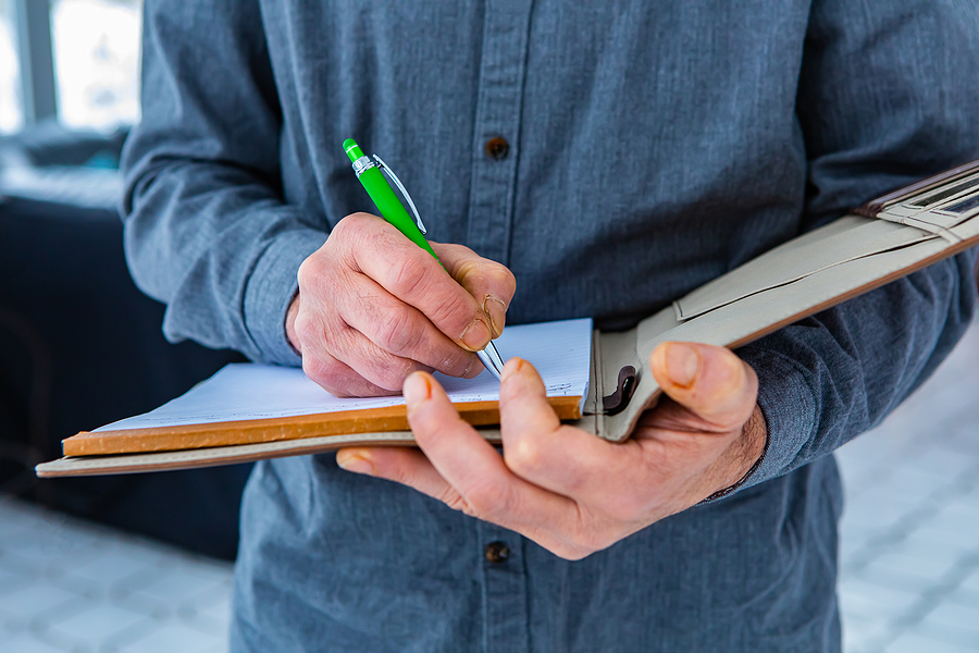 man writing on his notebook